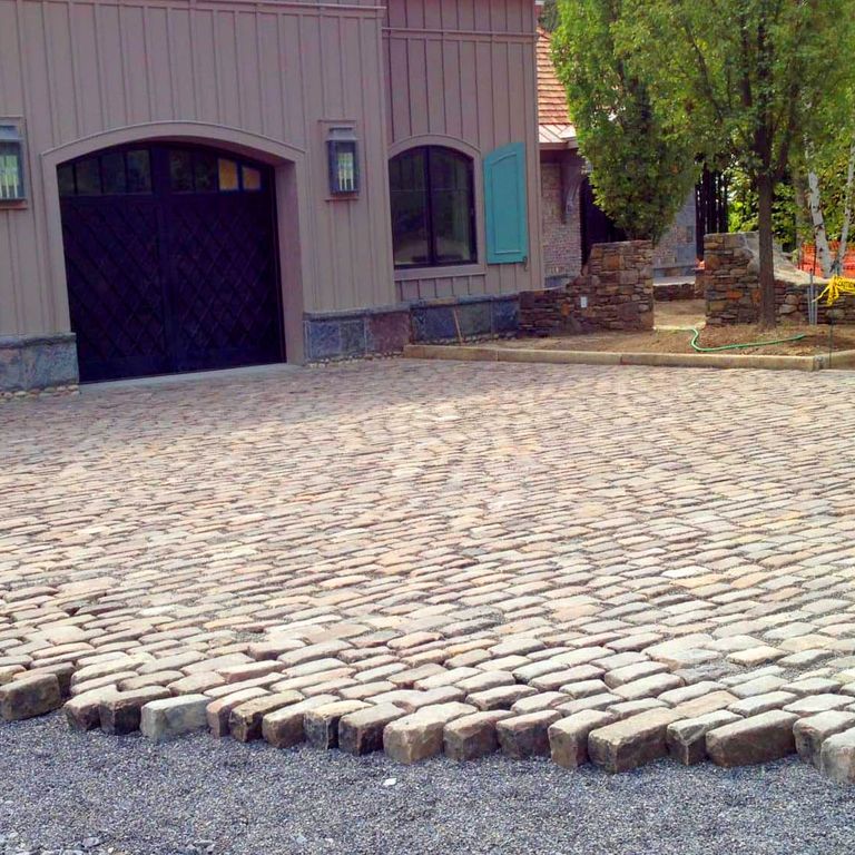 The image shows this material being used in a driveway pavers application.