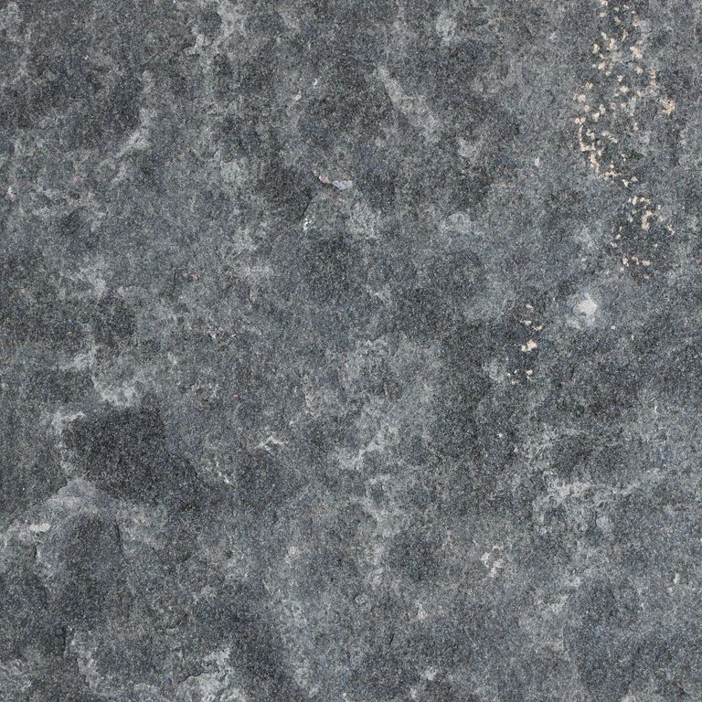 Close-up image for Nordic Black Basalt. The surface finish shown is flamed. The dominant color shown is gray; with black, blue, brown, green and purple secondaries. The color mix creates a cool feeling. Regular, fine speckled and blotched color patterns.