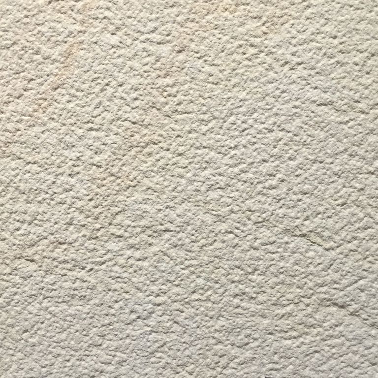 Color/Finish variation image for Portland White Sandstone. The surface finish shown is bush hammered. Dominant colors shown are beige and cream; with gray, white and tan secondaries. The color mix creates a warm feeling. Speckled color pattern.