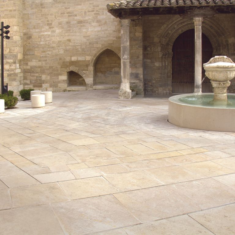 Feature image for Cream Limestone. The image shows this material being used in a patio pavers application. Dominant colors shown are beige and tan; with gray, orange/rust and cream secondaries. The color mix creates a warm feeling. Regular color pattern.