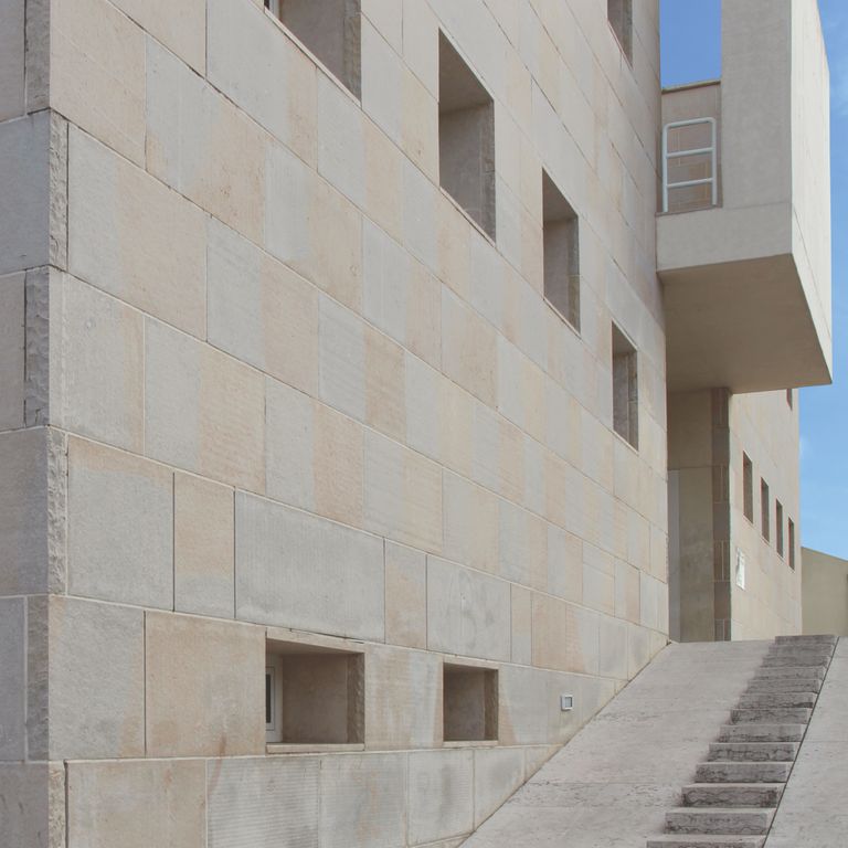 Feature image for Valamaza Limestone. The image shows this material being used for full bed veneer and thin veneer. Dominant colors shown are beige and gray; with brown, white and tan secondaries. The color mix creates a cool feeling. Regular color pattern.