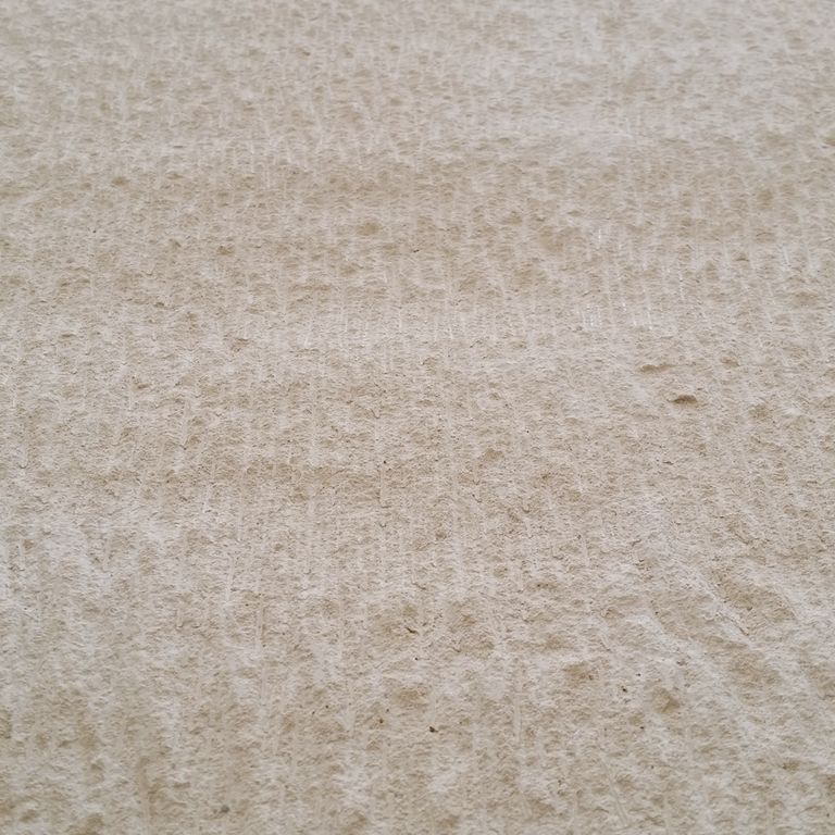 Color/Finish variation image for Portuguese Pacific Beige Limestone. The surface finish shown is chiseled. The dominant color shown is beige; with brown, white and tan secondaries. The color mix creates a warm feeling. Regular color pattern.