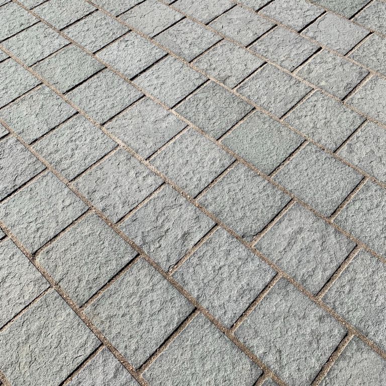 Best close-up image for Italian Bluestone. The image shows this material being used for driveway pavers and patio pavers. The surface finish shown is flamed. Dominant colors shown are blue and gray; with beige, green, pink and white secondaries. Regular, fine speckled and speckled color patterns.