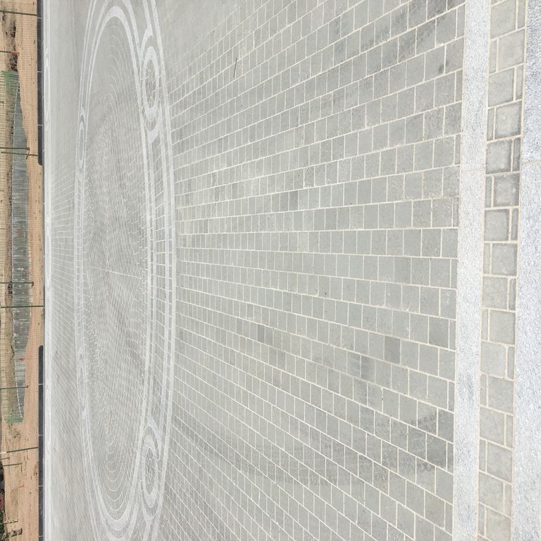 Application image for Bluestone - Italian. The image shows this material being used for patio pavers and public area. The dominant color shown is gray.