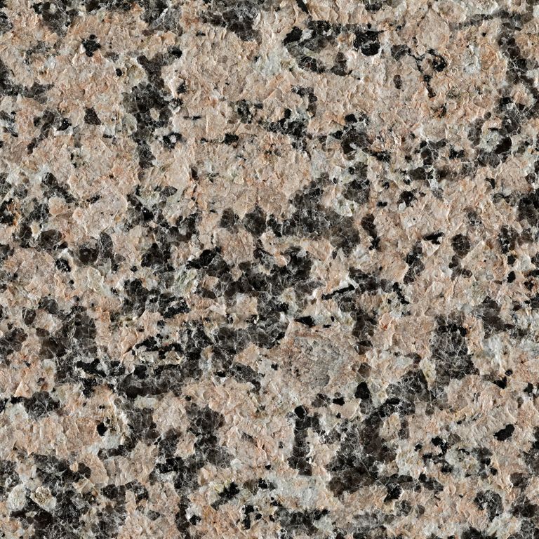 Best close-up image for Granite - Pink Porrino. The surface finish shown is flamed. The dominant color shown is pink; with beige, black, brown, white and cream secondaries. Exhibits 