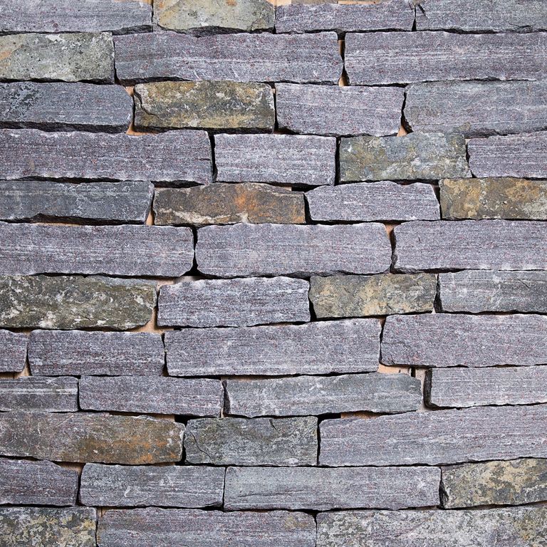 Close-up image for Dolph Pond Granite. The surface finishes shown are split-face and weathered. Dominant colors shown are blue and gray; with brown, orange/rust, purple, white and tan secondaries. Exhibits 