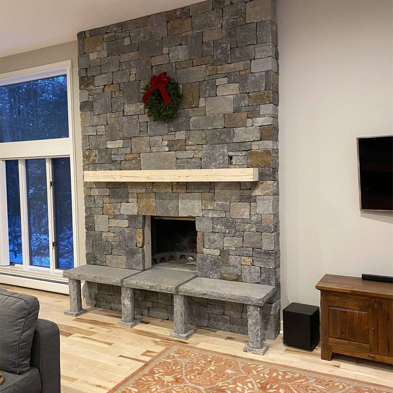 Feature image for Granite - Lake Champlain. The image shows this material being used for fireplace surround, full bed veneer, thin veneer and interior cladding. Dominant colors shown are beige, brown, gray and tan; with orange/rust, purple and cream secondaries. The color mix creates a warm feeling. Speckled, blotched and cloudy color patterns.
