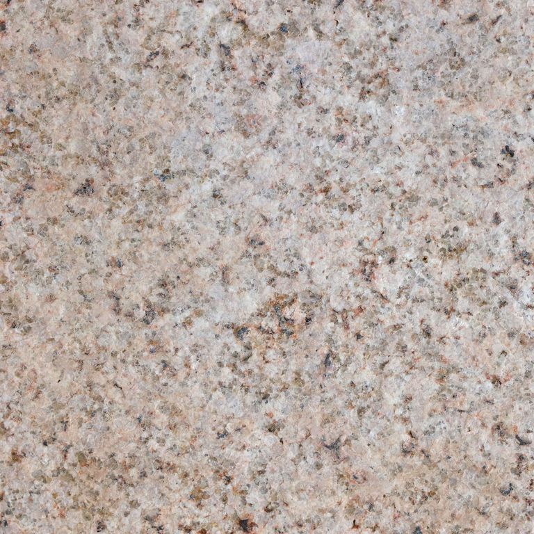Best close-up image for Golden Granite. The surface finish shown is flamed. Dominant colors shown are beige, gray and tan; with black, blue, brown, orange/rust, pink, purple, white and cream secondaries. The color mix creates a warm feeling. Regular and speckled color patterns. Contains some mica and mineral inclusions.