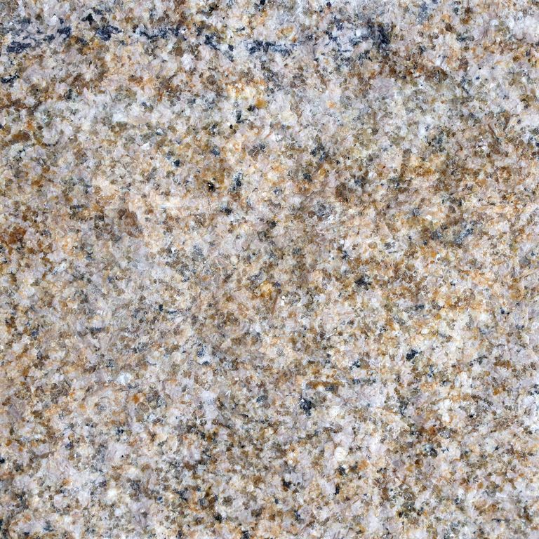Feature image for Golden Granite. The surface finish shown is split-face. Dominant colors shown are beige, brown, gray and tan; with black, green, orange/rust, pink, purple, white and cream secondaries. The color mix creates a warm feeling. Speckled and random color patterns. Contains some mica and mineral inclusions.
