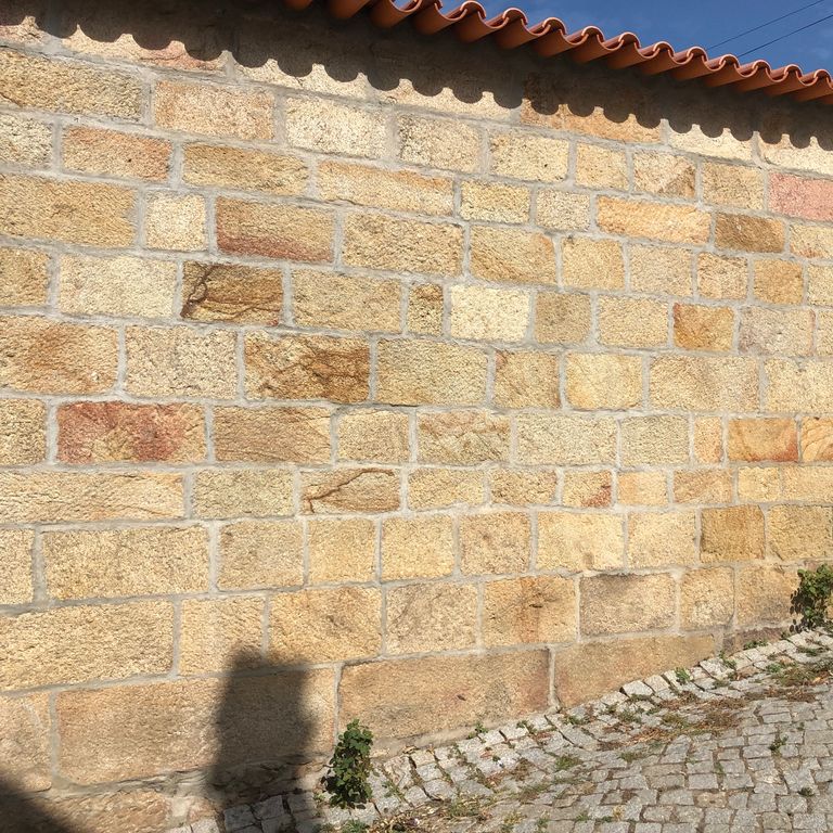 The image shows this material being used in a landscape wallstone application.