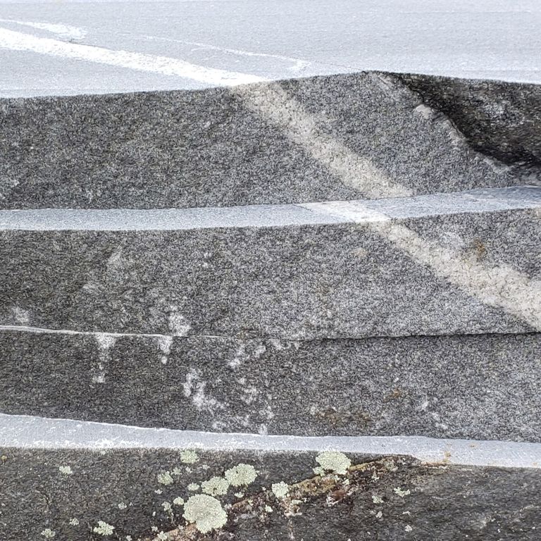 Close-up image for Fitzwilliam Granite. The surface finishes shown are natural and sawn. The dominant color shown is gray; with a gray secondary. Exhibits 