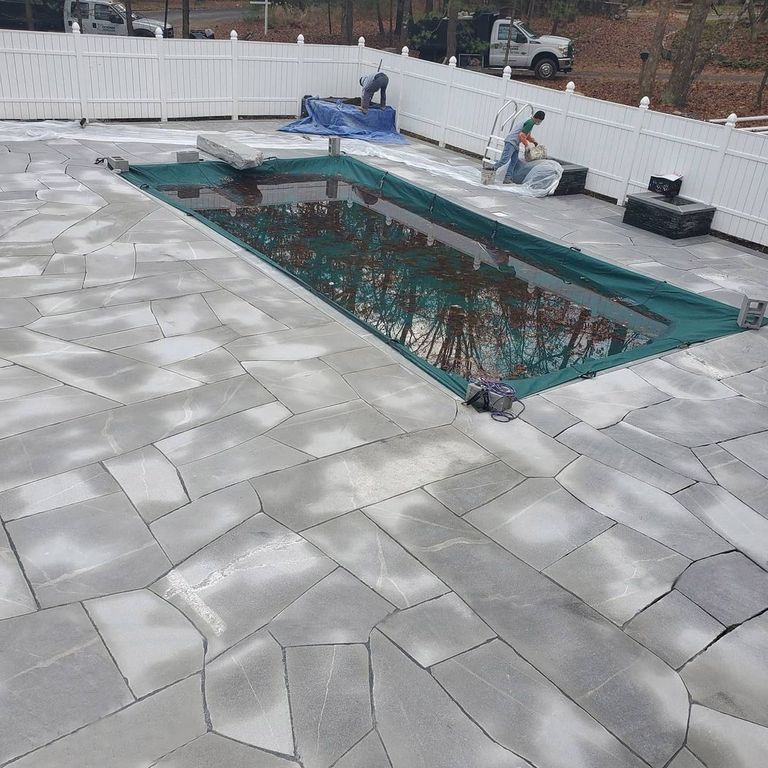 The image shows this material being used in a patio pavers application.