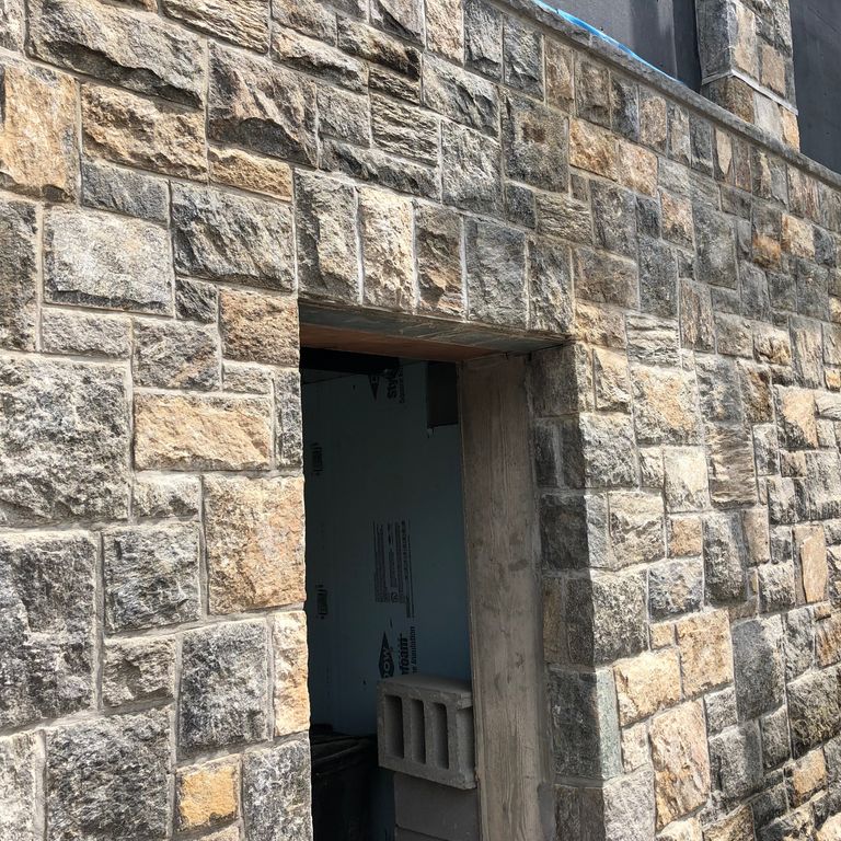 Feature image for Old New England Wall Fieldstone. The image shows this material being used for full bed veneer and thin veneer. Dominant colors shown are gray and tan; with beige, brown, orange/rust, purple and cream secondaries. The color mix creates a warm feeling. Random, speckled and blotched color patterns.