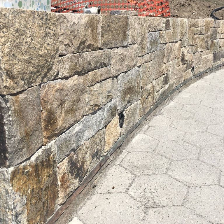 Application image for Granite - Nutmeg Ridge. The image shows this material being used for full bed veneer and thin veneer.