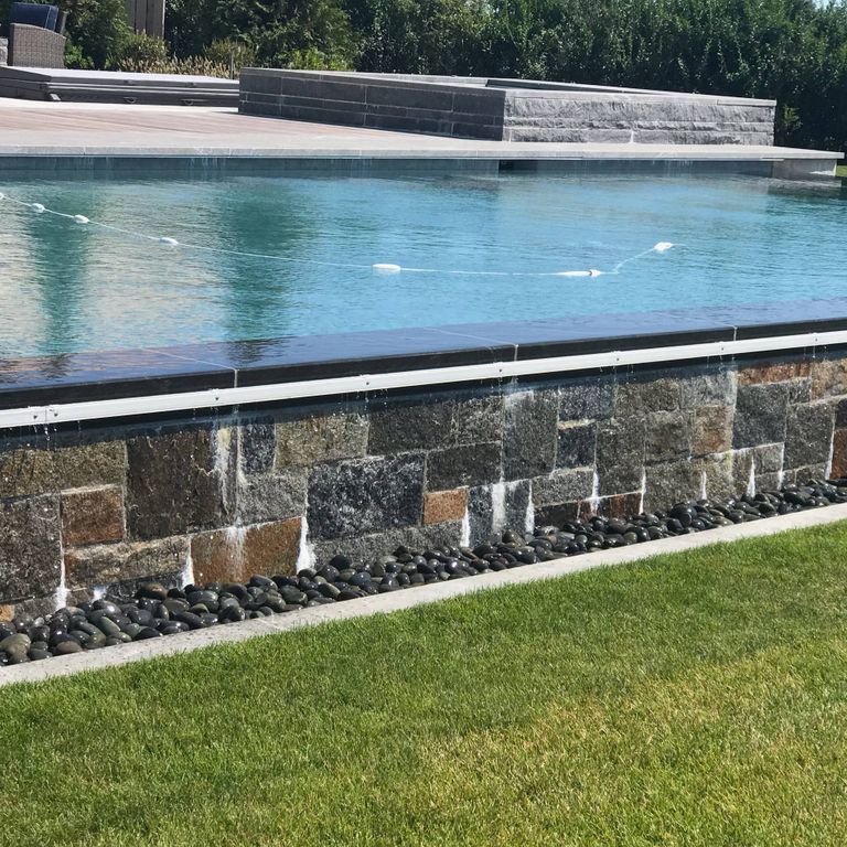 Application image for Granite - Connecticut Blend Thin Veneer. The image shows this material being used for pool coping and pool deck pavers.