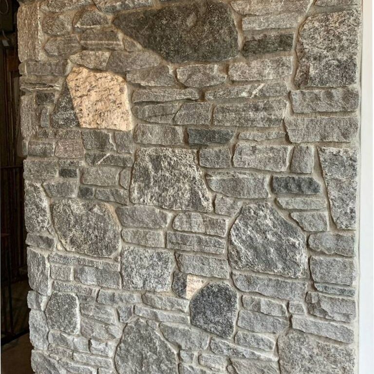 Application image for Greenwich Blue Granite. The image shows this material being used for full bed veneer and thin veneer. The surface finish shown is split-face. The dominant color shown is gray. The color mix creates a warm feeling. Regular color pattern.