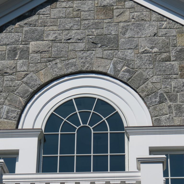 Application image for Greenwich Blue Granite. The image shows this material being used for full bed veneer and thin veneer. The surface finish shown is split-face. The dominant color shown is gray. The color mix creates a cool feeling. Regular color pattern.