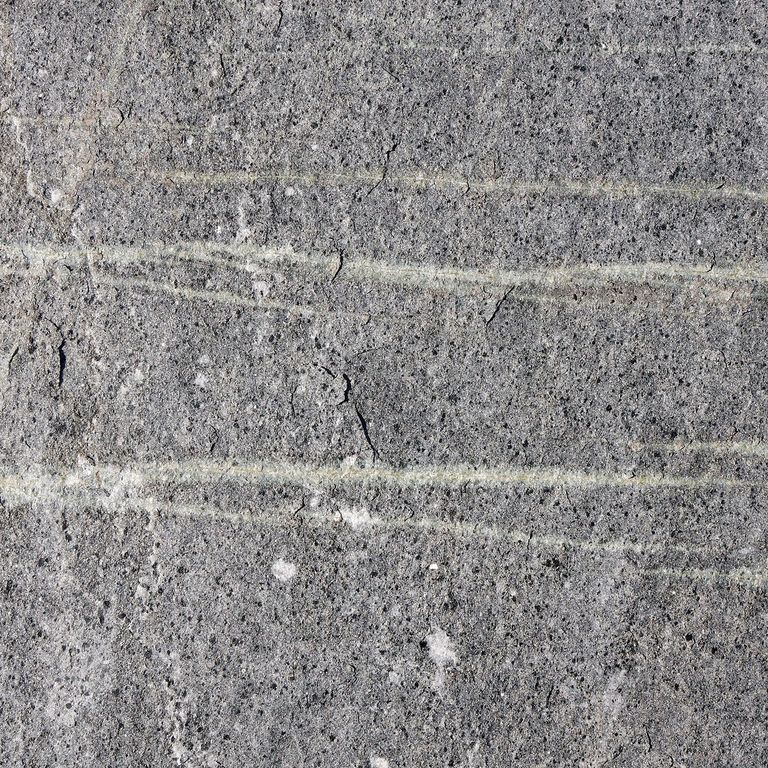 Color/Finish variation image for American Mist Granite. The surface finish shown is flamed. The dominant color shown is gray; with black, blue, brown, green, purple and white secondaries. Exhibits 
