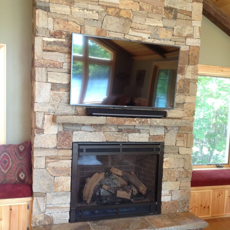 Feature image for Granite - Colonial Tan. The image shows this material being used for fireplace surround, full bed veneer, thin veneer and interior cladding. Dominant colors shown are beige, brown and tan; with gray, orange/rust, purple and cream secondaries. The color mix creates a warm feeling. Random color pattern.