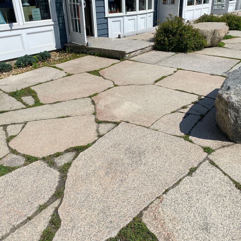 Feature image for Granite - Millenium. The image shows this material being used for patio pavers and public area. Dominant colors shown are beige and gray; with orange/rust, pink and tan secondaries. Exhibits 