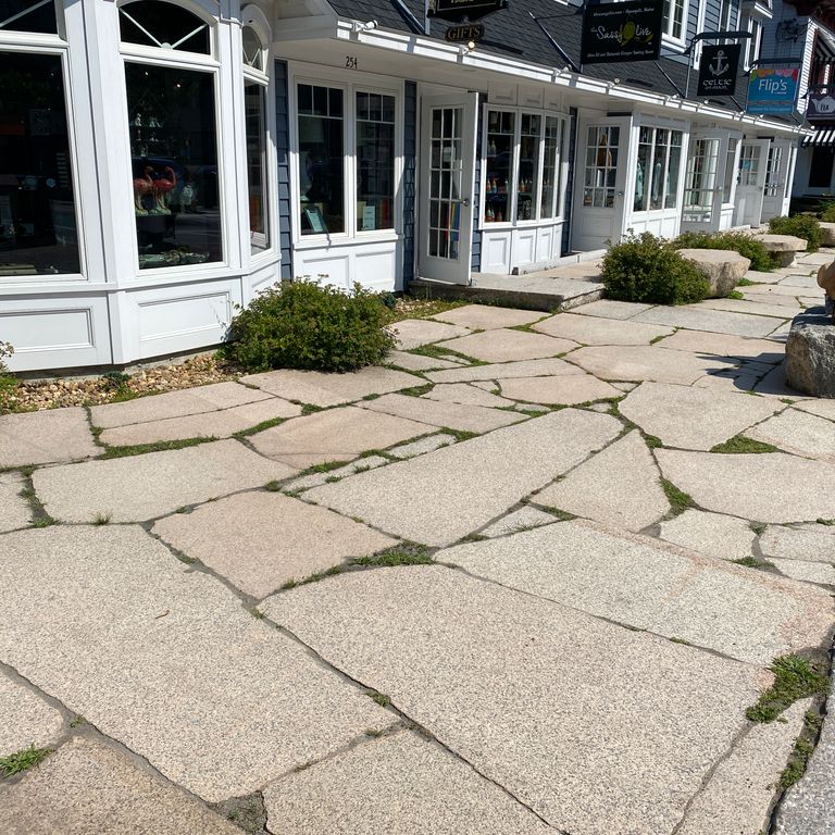 Application image for Granite - Millenium. The image shows this material being used for patio pavers and monolithic steps. The surface finish shown is flamed. Dominant colors shown are beige, gray and tan. The color mix creates a warm feeling. Speckled color pattern.