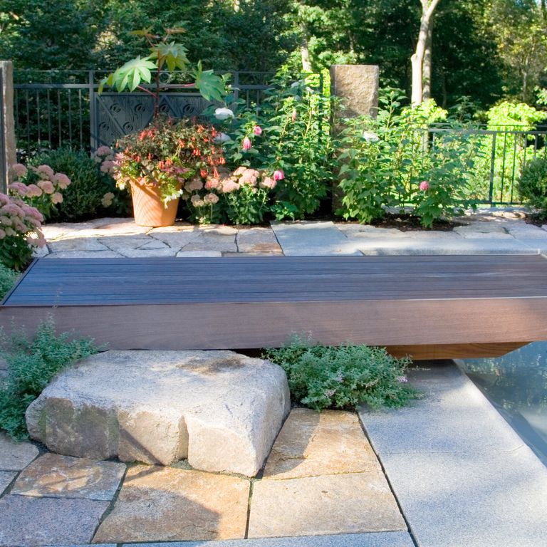 Application image for Millenium Granite. The image shows this material being used for patio pavers and monolithic steps. The surface finish shown is flamed. Dominant colors shown are gray and tan. The color mix creates a warm feeling. Fine speckled color pattern.