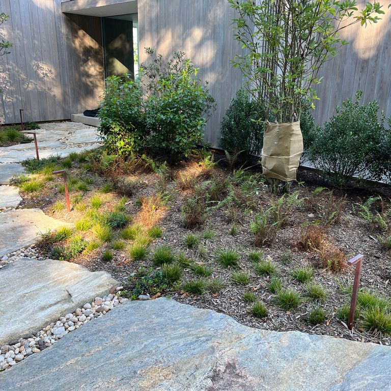 Application image for Black Mountain Granite - Natural. The image shows this material being used in a path pavers application. The surface finish shown is natural. Dominant colors shown are blue and gray. Exhibits 