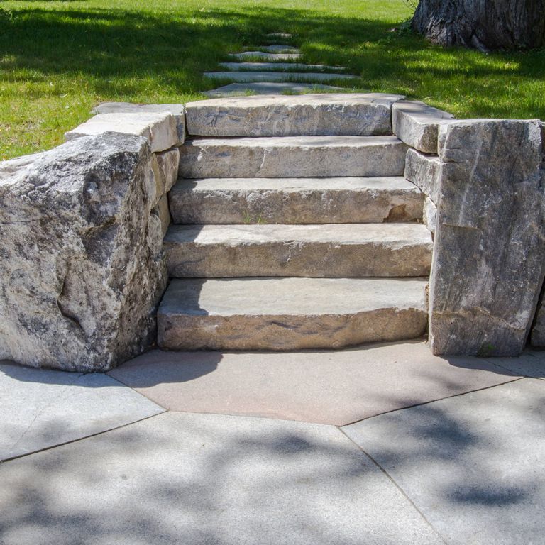 Application image for Black Mountain Granite - Natural. The image shows this material being used in a monolithic steps application. This is a building and landscape stone for indoor and outdoor commercial and residential applications. Suitable for general use, freeze-thaw conditions, low heat absorption surfaces, high traffic areas and low slipperiness surfaces situations. Moderate to higher on the price spectrum.