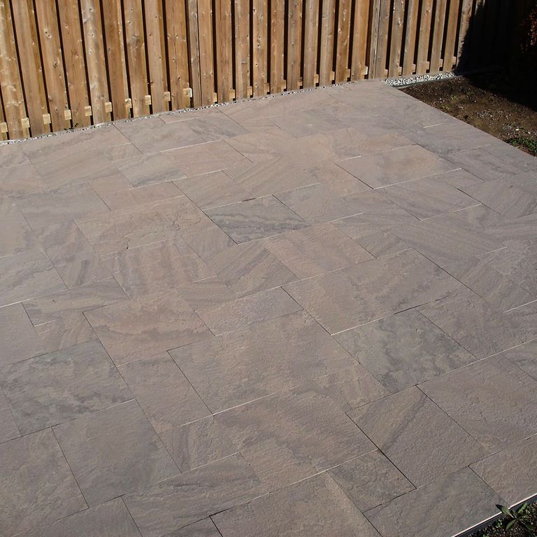 The image shows this material being used in a patio pavers application.