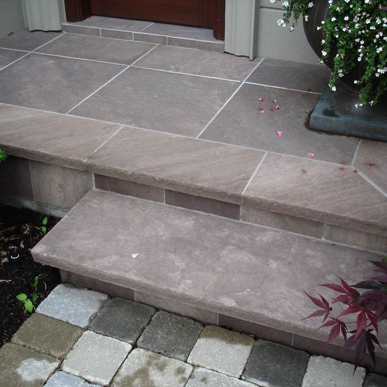 Application image for Sandstone - Brown Wave. The image shows this material being used for patio pavers and treads. The dominant color shown is gray.
