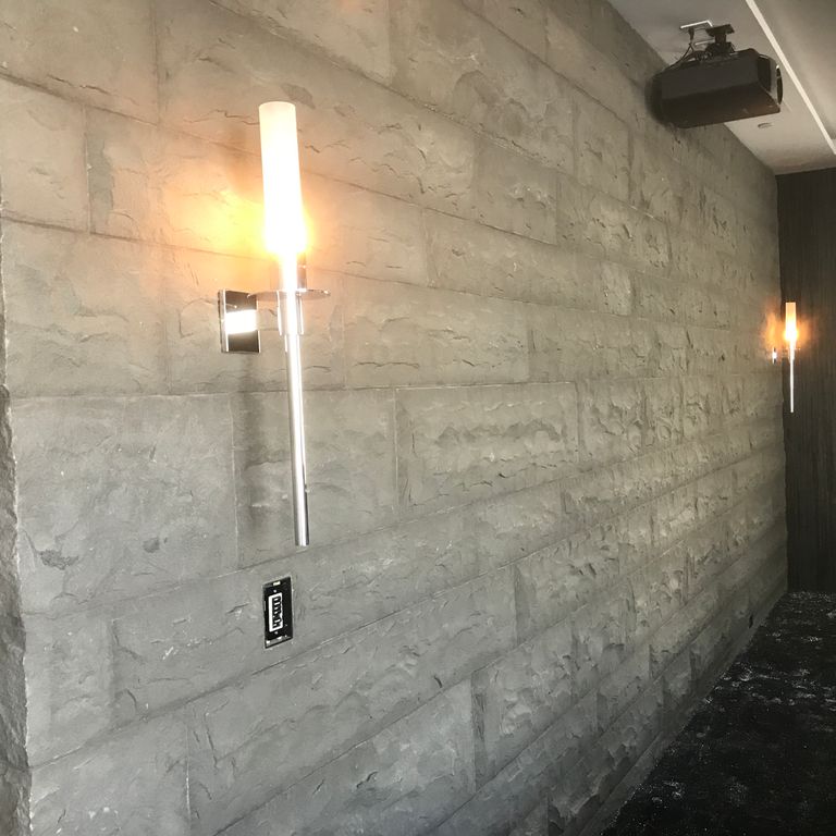 Feature image for Ankar Gray Basalt. The image shows this material being used for full bed veneer and thin veneer. The dominant color shown is gray. The color mix creates a cool feeling. Regular color pattern.