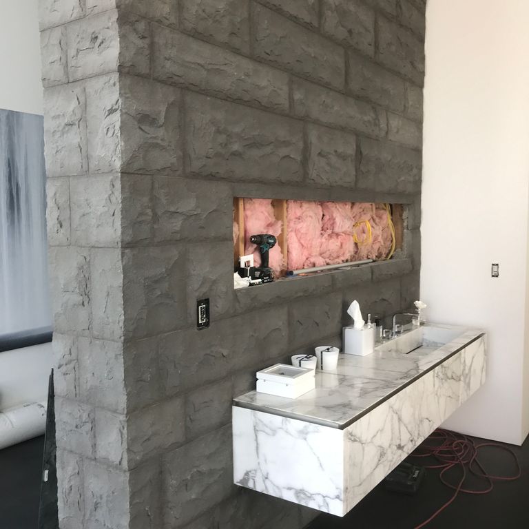 Application image for Basalt - Ankar Gray. The image shows this material being used for full bed veneer, thin veneer and interior cladding. The dominant color shown is gray. The color mix creates a warm feeling.