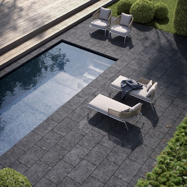 Application image for Limestone - Belgian Bluestone. The image shows this material being used for pool coping and pool deck pavers. The surface finish shown is flamed. The dominant color shown is gray. The color mix creates a warm feeling. Regular color pattern.