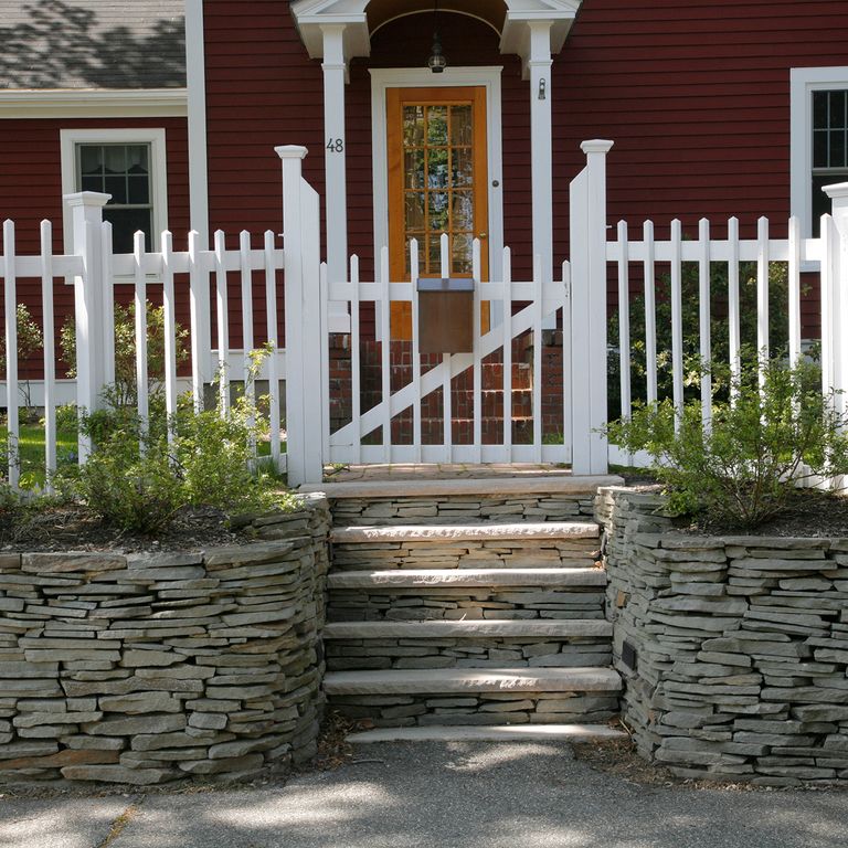 Application image for Bluestone - Blue/Gray - Natural Cleft Surface. The image shows this material being used in a landscape wallstone application.