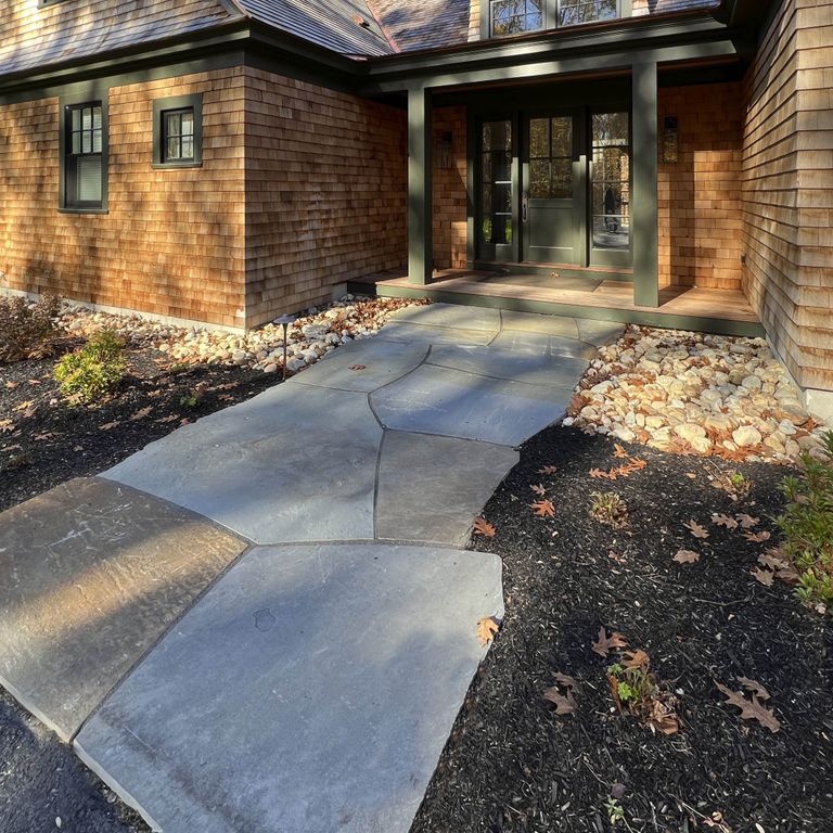 Application image for Bluestone Natural Cleft - Full Color Mix. The image shows this material being used in a path pavers application. The surface finish shown is natural cleft. Dominant colors shown are brown and gray. The color mix creates a cool feeling. Regular and random color patterns.