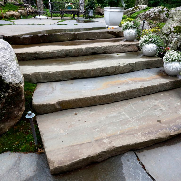 Application image for Bluestone Natural Cleft - Full Color Mix. The image shows this material being used in a monolithic steps application. This is a building and landscape stone for indoor and outdoor commercial and residential applications. Suitable for general use, freeze-thaw conditions, high traffic areas, low slipperiness surfaces and high heel compatibilty situations. Low to moderate on the price spectrum.