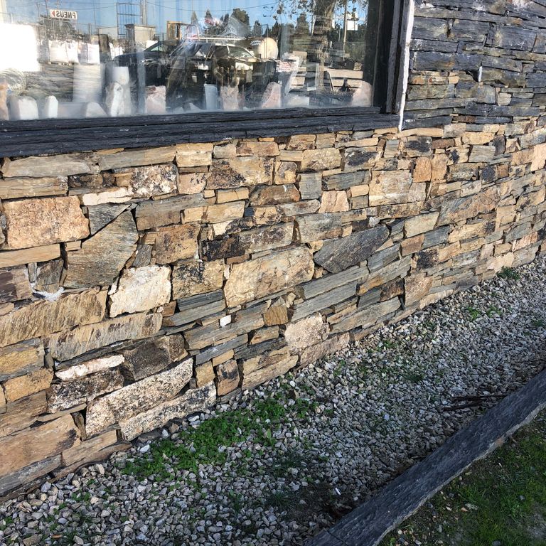Feature image for Oxidized Shale. The image shows this material being used for full bed veneer and thin veneer. The dominant color shown is gray; with beige, brown, orange/rust, purple, tan and cream secondaries. The color mix creates a warm feeling. Random color pattern.