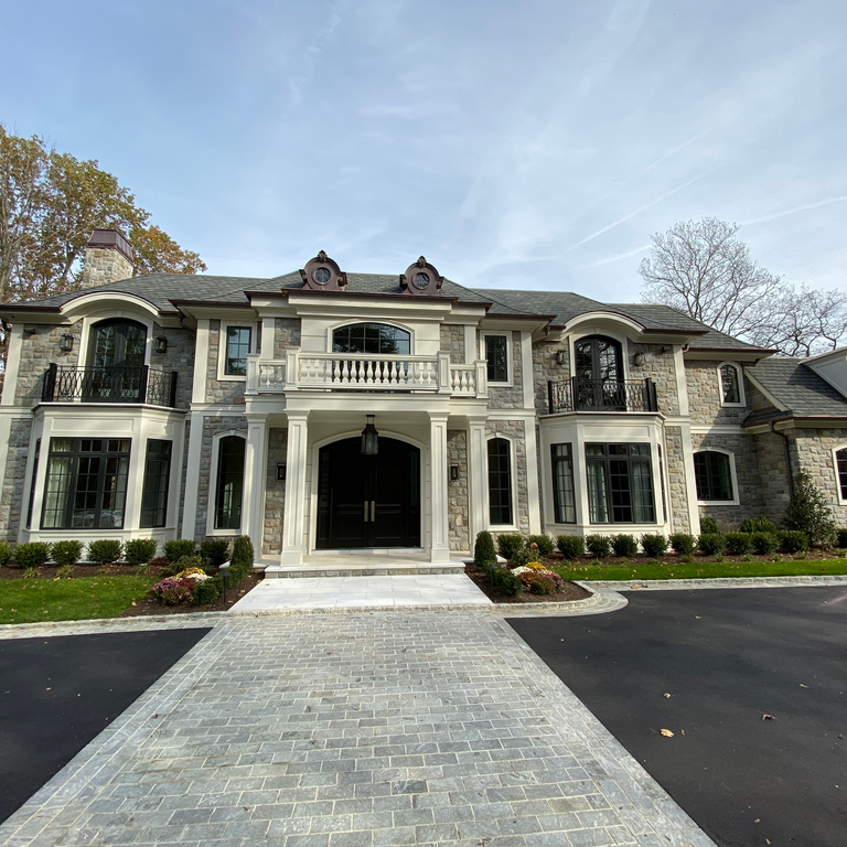 Application image for Adirondack Elite Granite. The image shows this material being used for full bed veneer and thin veneer. The surface finish shown is split-face. The dominant color shown is gray; with beige, brown and tan secondaries. The color mix creates a warm feeling.