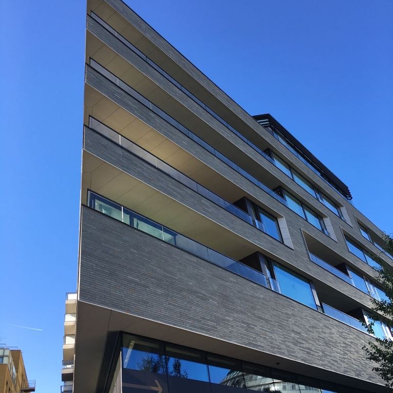 Feature image for Barcelona Limestone. The image shows this material being used in a thin veneer application. The dominant color shown is gray; with black, blue, green and purple secondaries. The color mix creates a cool feeling. Regular color pattern.