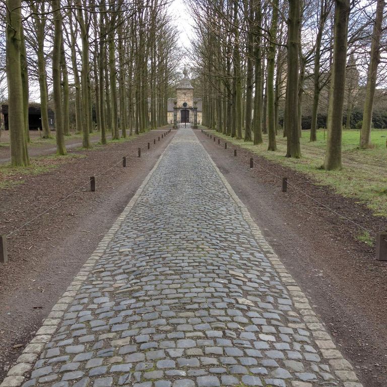 Application image for Reclaimed Belgian Bluestone Cobblestones. The image shows this material being used in a driveway pavers application. The surface finish shown is . The dominant color shown is gray. The color mix creates a cool feeling.