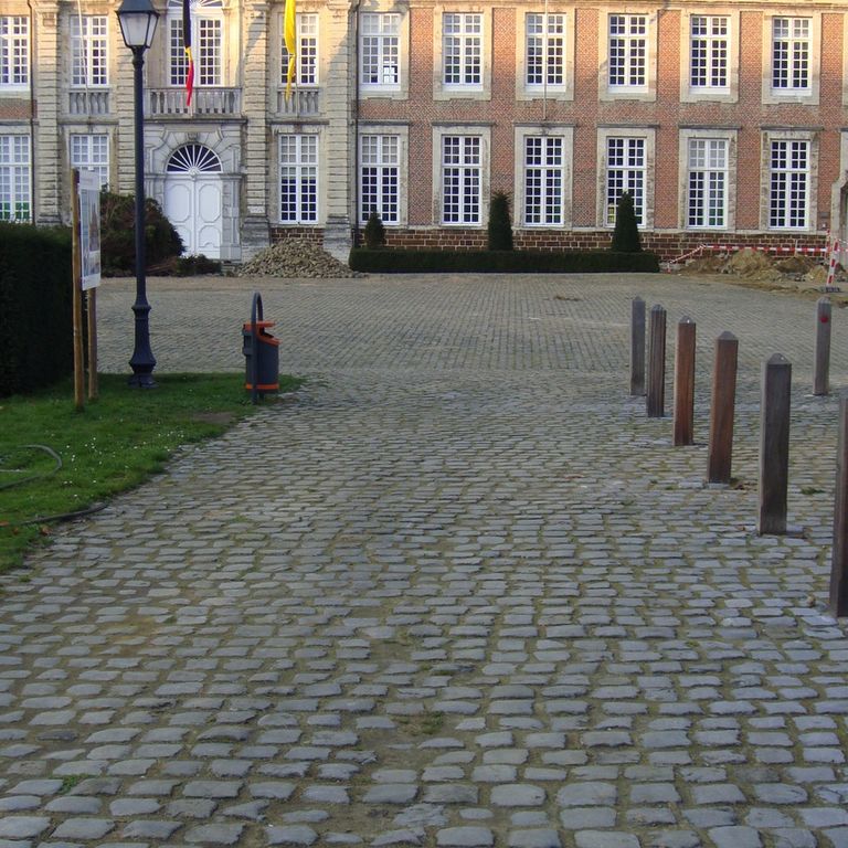 Application image for Reclaimed Belgian Bluestone Cobblestones. The image shows this material being used in a public area application. The surface finish shown is . The dominant color shown is gray. The color mix creates a warm feeling.