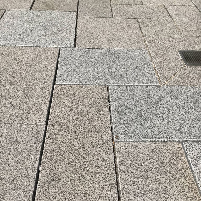 Close-up image for Reclaimed Rockport Granite. The surface finishes shown are flamed, weathered and worn. Dominant colors shown are beige and gray; with pink, white, tan and cream secondaries. The color mix creates a warm feeling. Speckled and fine speckled color patterns.