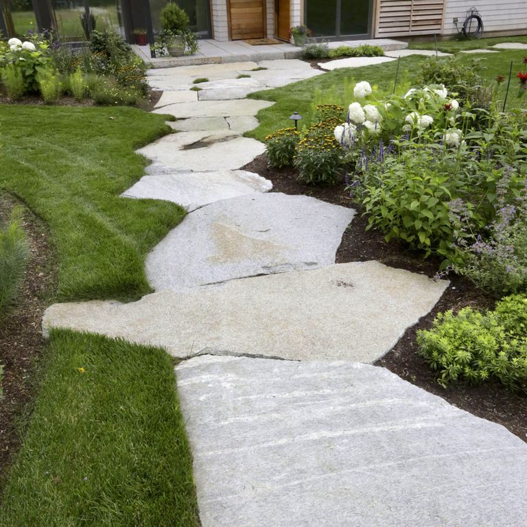 Application image for Dodlin Hill Granite. The image shows this material being used in a path pavers application. The surface finish shown is natural cleft. The dominant color shown is gray; with beige, brown and white secondaries. Exhibits 
