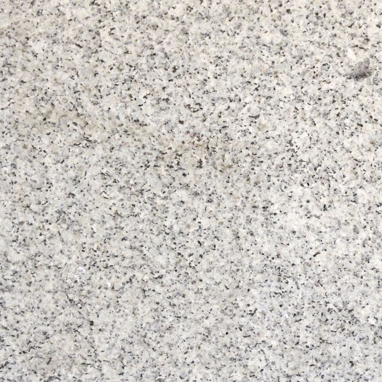 Color/Finish variation image for Kitledge Gray Granite. The surface finish shown is flamed. Dominant colors shown are beige, gray and white; with pink and cream secondaries. The color mix creates a cool feeling. Coarse speckled color pattern.