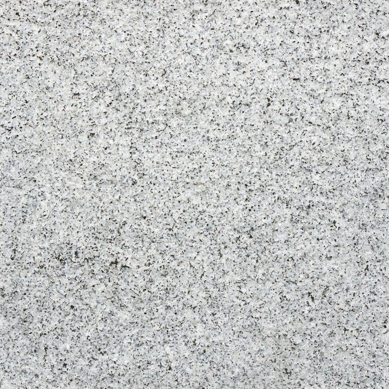 Best close-up image for Kitledge Gray Granite. The surface finish shown is flamed. Dominant colors shown are beige, gray and white; with pink, purple, white and cream secondaries. The color mix creates a cool feeling. Fine speckled color pattern. Contains some mica.
