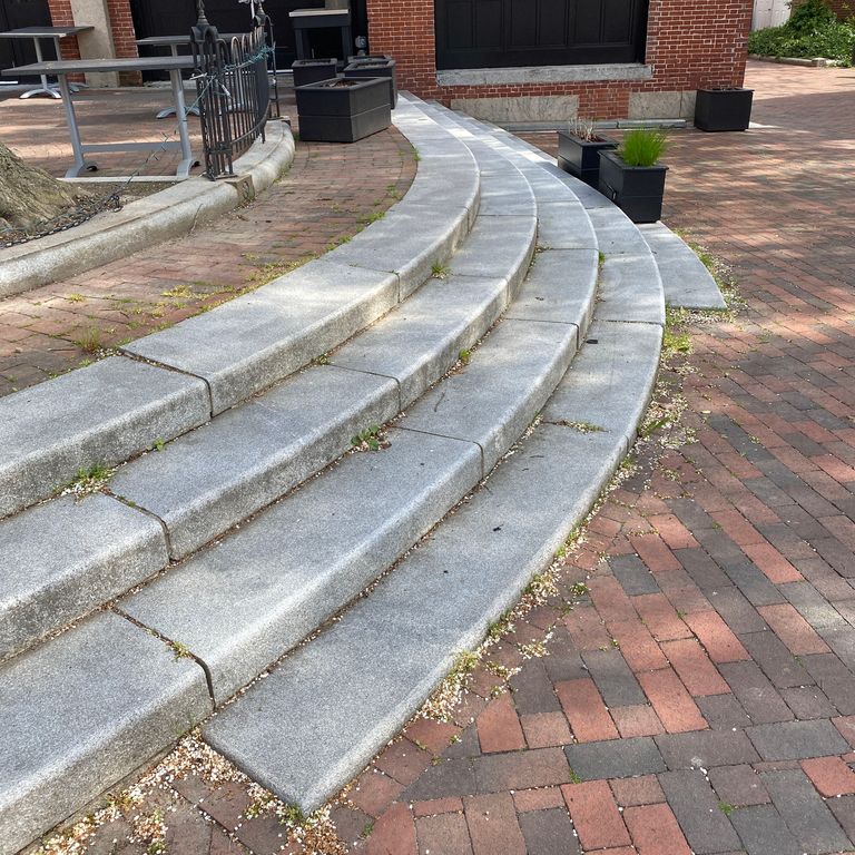 Application image for Kitledge Grey Granite. The image shows this material being used in a monolithic steps application. This is a building and landscape stone for indoor and outdoor commercial and residential applications. Suitable for general use, freeze-thaw conditions, low heat absorption surfaces, high traffic areas, low slipperiness surfaces and high heel compatibilty situations. Moderate to higher on the price spectrum.