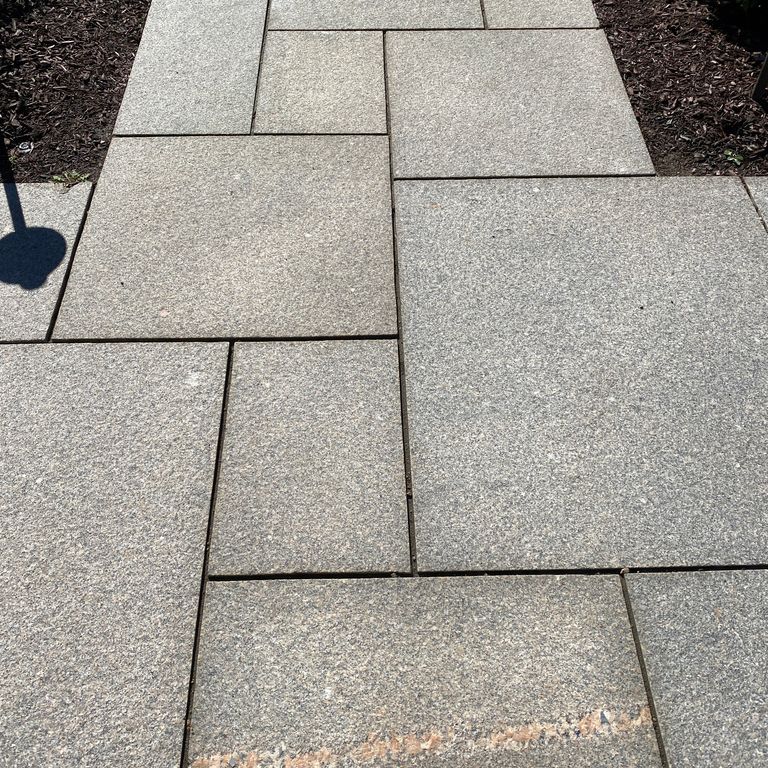 Feature image for Mason Granite. The image shows this material being used in a path pavers application. The dominant color shown is gray; with beige, pink, purple, white and tan secondaries. The color mix creates a warm feeling. Speckled color pattern.