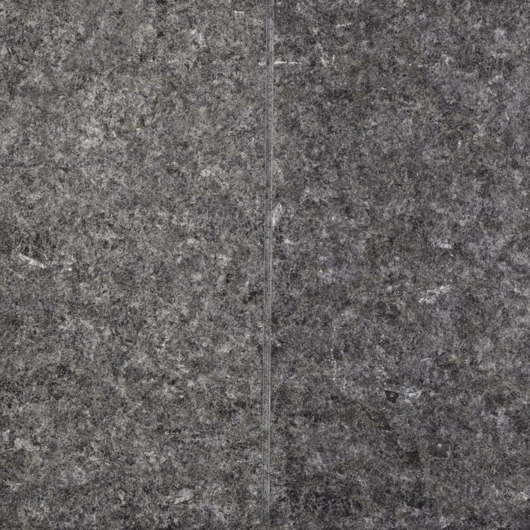 Feature image for Peribonka Granite. The surface finish shown is flamed. The dominant color shown is gray; with black, brown and purple secondaries. The color mix creates a cool feeling. Speckled color pattern. Contains some mica and mineral inclusions.