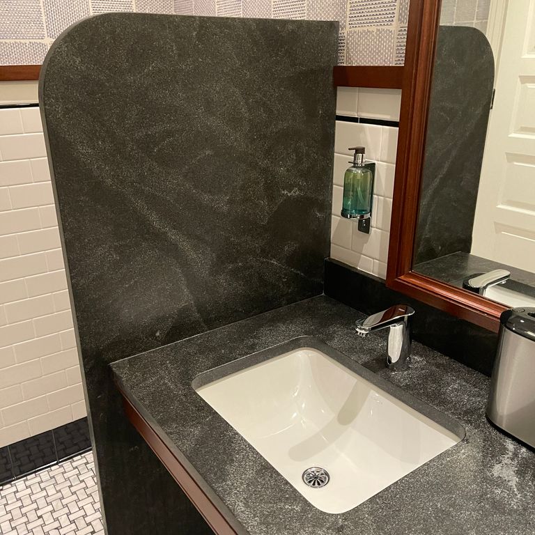 Application image for Jet Mist Granite. The image shows this material being used for countertop slabs and sinks. This is a building and landscape stone for indoor and outdoor commercial and residential applications. Suitable for general use, freeze-thaw conditions, high traffic areas, low slipperiness surfaces and high heel compatibilty situations. Moderate to higher on the price spectrum.