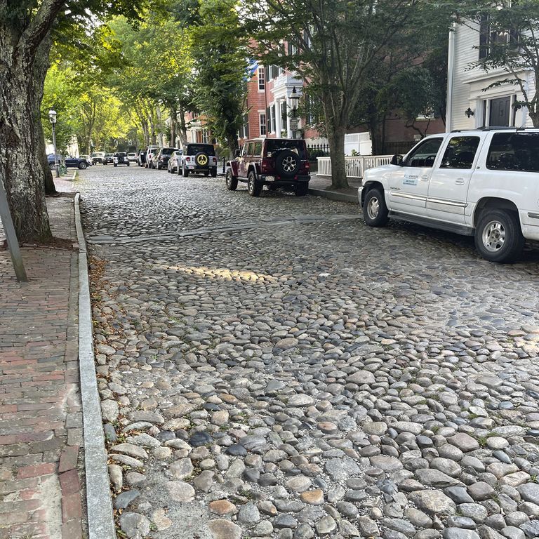 Application image for Beach Rounds. The image shows this material being used in a driveway pavers application. The surface finish shown is . The dominant color shown is gray. The color mix creates a warm feeling. Regular color pattern.